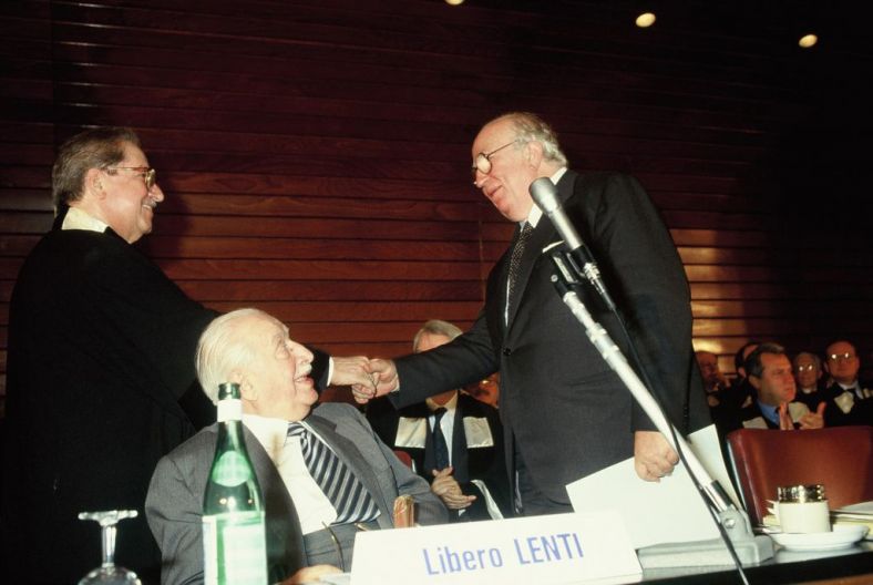 Giovanni Spadolini saluta Ariberto MIgnoli. Seduto al tavolo di presidenza Libero Lenti Giovanni Spadolini saluta Ariberto MIgnoli. Seduto al tavolo di presidenza Libero Lenti